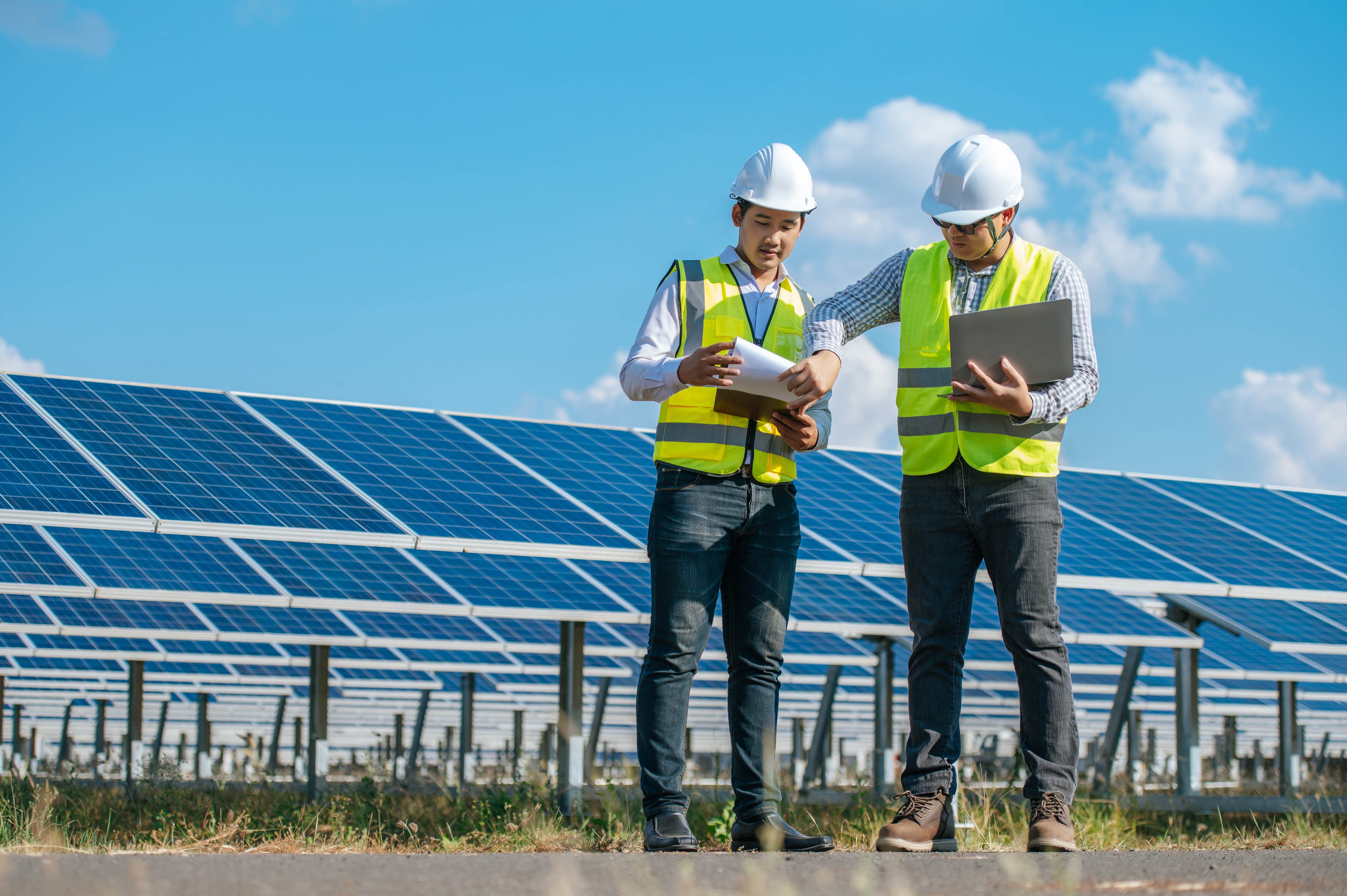 Two engineers are discussing during working at solar farm